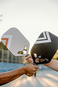 Pickleball Schläger Bild für den Pickleball Ausrüstung Guide. zwei moderne Paddles im Sonnenlicht, bereit fürs Spiel