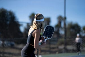 Pickleball in der Nähe Symbolbild. Frau spielt Pickleball auf einem Outdoor-Court